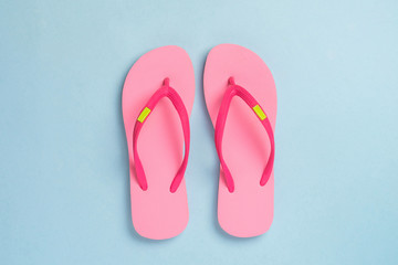 Pink sandals isolated on blue pastel background.