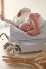 Fototapeta na wymiar The newborn baby lies down on a weight scale.