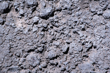 .The texura is not flat, sunken gray concrete. Gray rocky background. Gray is not even concrete