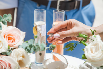 Bride and groom exchanging wedding rings close up during symbolic nautical decor destination wedding marriage on sandy beach in front of the ocean in Punta Cana, Dominican republic 
