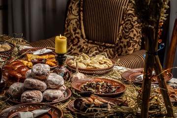 Christmas table in Ukraine. Twelve meatless dishes: kutya, stewed fruit, dumplings with potatoes and cabbage, pickled mushrooms, donuts, garlic, fried and smoked fish, herring