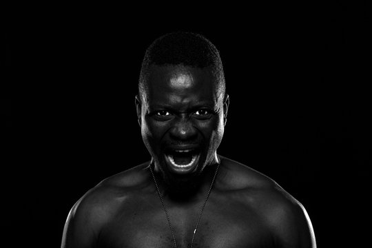 Hombre negro sobre fondo negro con expresi&oacute;n de furia