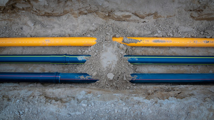 Baustelle mit Rohre für Tiefbau im Baugebiet. Versorgung für Gas, Lichtwellenleiter, Glasfaser,...