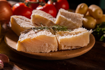 salted codfish on the wooden table with ingredients. Codfish raw.