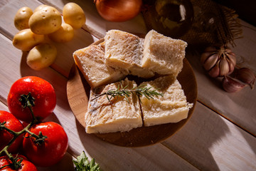 salted codfish on the wooden table with ingredients. Codfish raw.