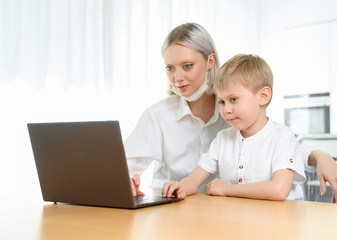 Boy child and girl study at a laptop at home.