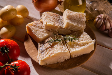 salted codfish on the wooden table with ingredients. Codfish raw.