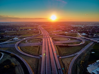 Obraz na płótnie Canvas A beautiful panoramic aerial drone view of the sunset on the highway overpass of the southern Warsaw bypass (Polish: POW), Michalowice district in Warsaw, Opacz Kolonia, Poland