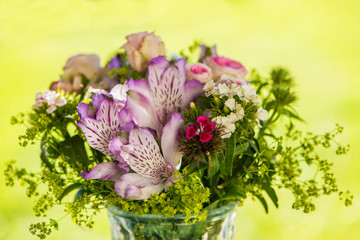 Naklejka na ściany i meble Little flower bouquet on a garden table