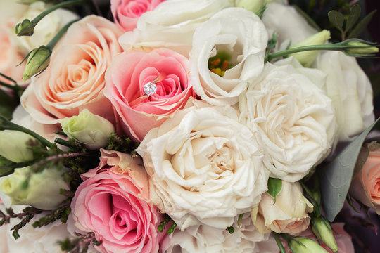 Perfect image with copy space for wedding magazines and websites, bohemian, fashion, florist. Flowers bouquet with nude roses and wedding rings. Copy space. Flowers background.