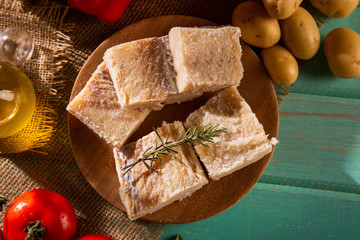 salted codfish on the wooden table with ingredients. Codfish raw.