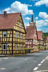 view of small viillage with half-timbered houses and cloudy blue sky