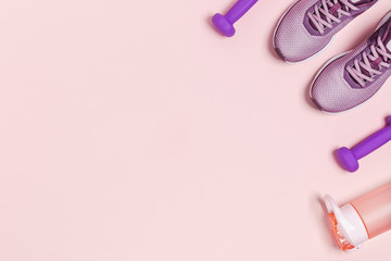 Sports color background. Sports equipment and shoes for women's training. Pink background, vertical picture.