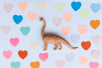 side view brachiosaurus toy on the background of colorful hearts. Concept of Valentine's Day.