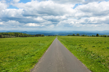 panoramic view of green fields and meadows and small road