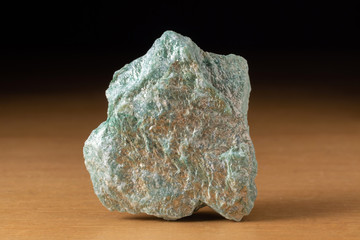 Rock of fuchsite mineral from Brazil over a wooden table
