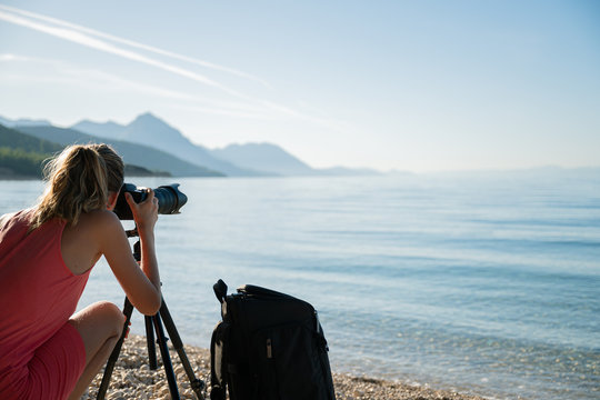 Young woman  taking photos of beautiful morning sea