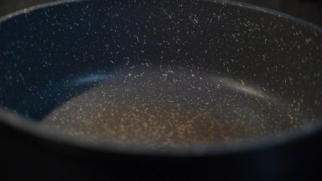 ein St&uuml;ck Butter in eine hei&szlig;e Pfanne zum Schmelzen geben