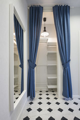 Compact entrance hall with open shelves and a full-length mirror in a classic style