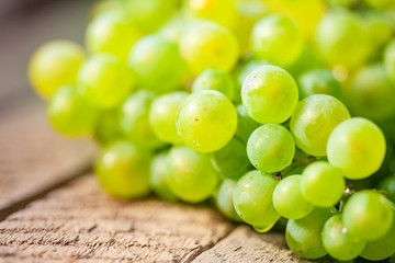 Green grape on a wooden barrel. Macro image.