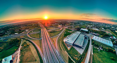 A beautiful panoramic aerial drone view of the sunset on the highway overpass of the southern...
