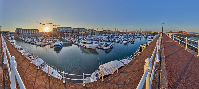 Panoramic image of Elizabeth Marina, St Helier early morning from the West marina wall with the entrance and Elizabeth Castle on the right hand side of the image. Jersey, Channel Islands, UK