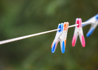 Bright coloured pins on clothes line closeup in forest with empty space