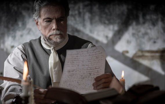 colonial man reading a document during the 1776 war