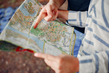 Tourists in a summer forest. Couple with a map.