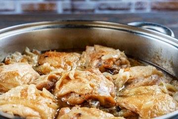 Chicken thighs fried in a pan, close-up, shallow depth of field, selective focus. Homemade food concept.