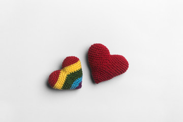 Colorful handmade woolen hearts on white background