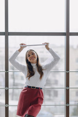 girl in light clothing holds a laptop over her head. learning and working in digital. the digital world as a basis.