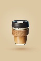 Levitation of reusable takeaway coffee cup with a cappuccino. Reusable coffee cups. Zero waste. Template for the coffee menu.