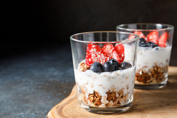 Granola parfait with oat cereal, fresh berries and greek yogurt in glass