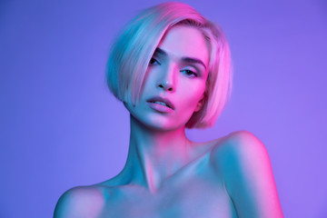 Sensual  blond young woman with  perfect skin in trendy glowing neon pink purple light.