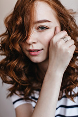 Close-up shot of pleased ginger woman wears trendy silver ring. Studio portrait of cheerful white girl with red hair.