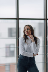 Fototapeta premium attractive girl on the background of the window shows different emotions and mood. girl on a light background indoors.