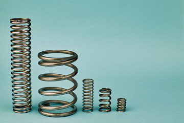 Springs of different sizes on a blue background. The different types of springs, including applications and industries.