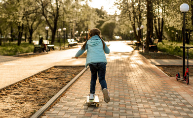 Fototapeta premium girl in the park on a skateboard in spring