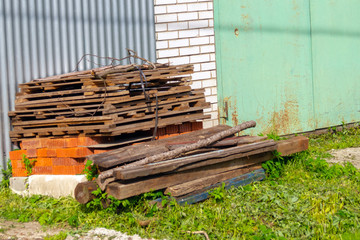 old boards and bricks piled at the garage door