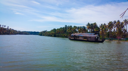 A houseboat sailing in Ashtamudi Lake in Kerala. Kerala Backwaters.