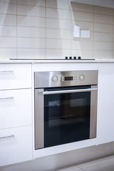 Built-in electric oven. Empty countertop. Modern kitchen interior in white