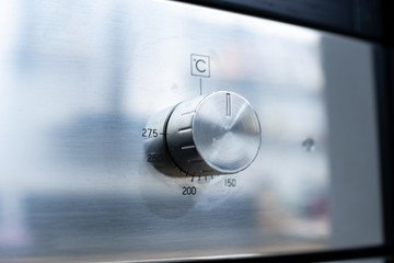 Knob Oven. Detail of a knob to regulate the temperature of the domestic oven. steel kitchen appliance. Electric oven with adjustment knob