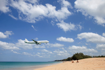 Fototapeta na wymiar a plane flies over the beach with people on a Sunny day