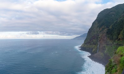 View of waterfalls flowing into the ocean close to Seixal town in Madeira