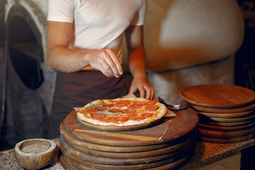 Chef prepare the pizzaa. Man in a white uniform