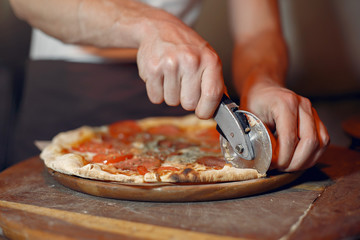 Chef prepare the pizzaa. Man in a white uniform