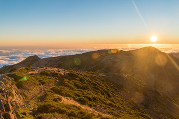 HDR of Sunset over the horizon filled with clouds hanging over the sea at Madeira