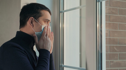 Man puts on medical surgical mask before going out