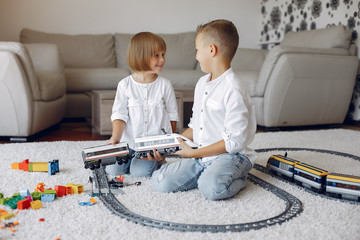 Brother and sister in a playing room. Children playing with a blocks. Kids with toy train